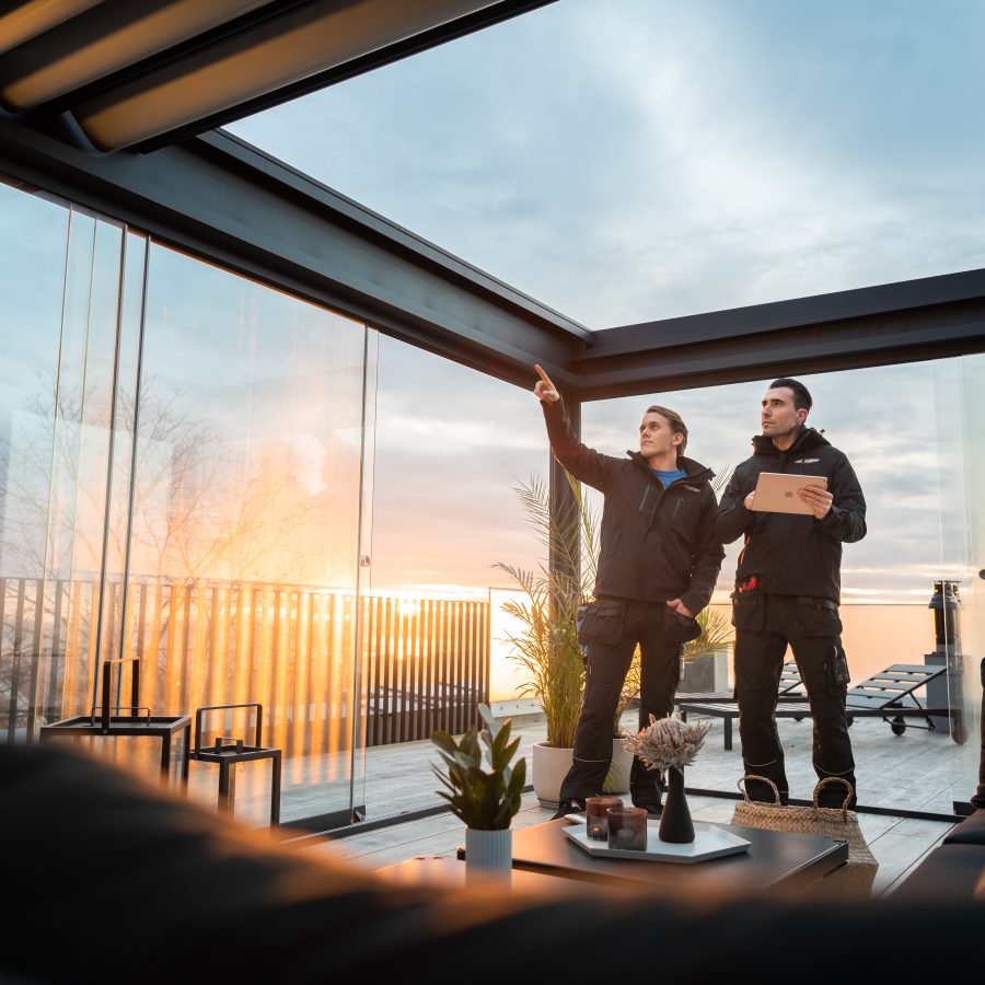 to elektrikere fra norgeseliten peker på elektroløsninger med blå himmel i bakgrunnen